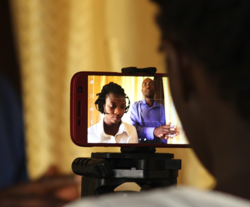 Close up of a smart phone filming a scene, two people a man and a woman, visible on the screen, during a cinemtography class