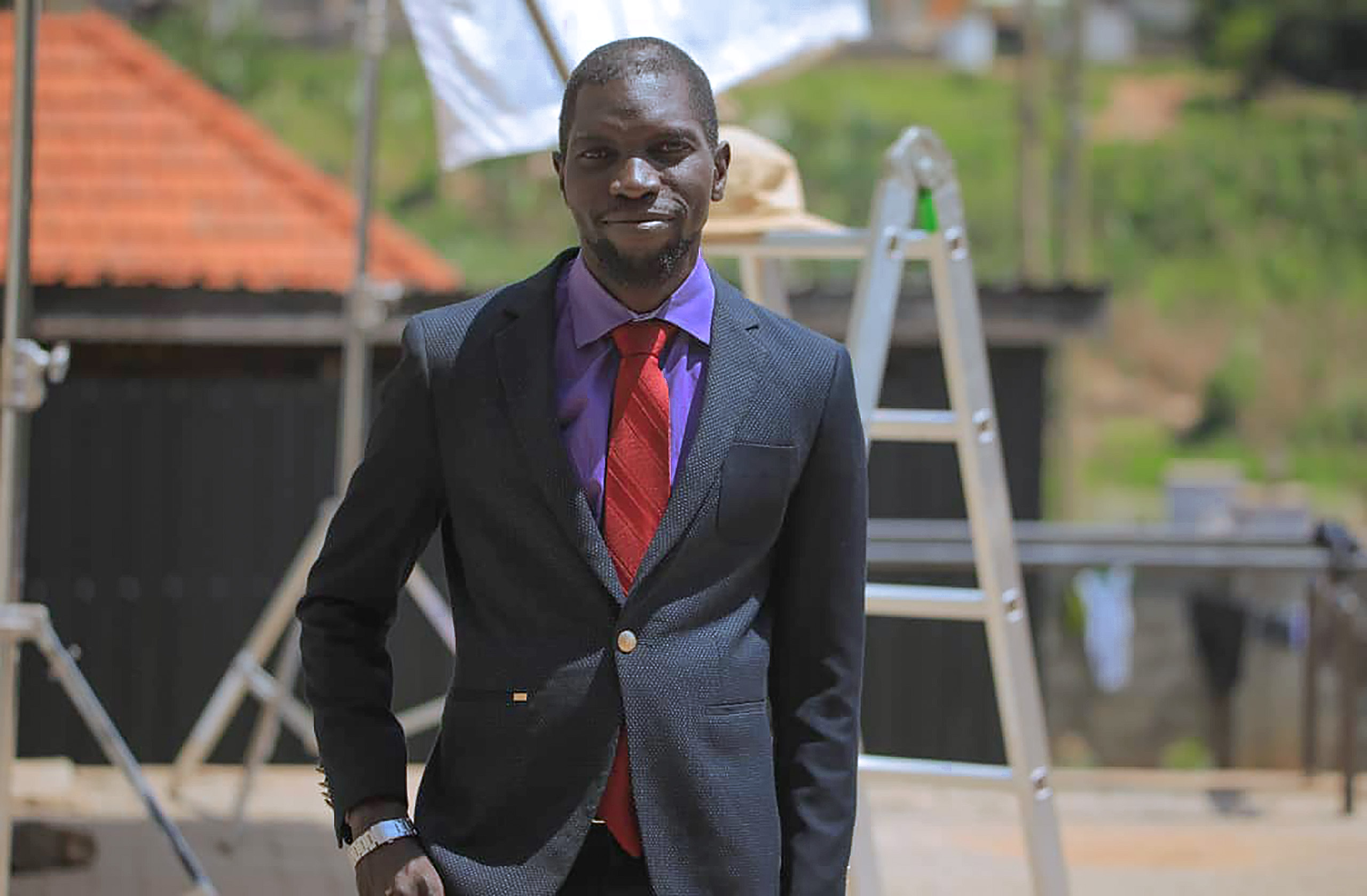 A man posing for a photo in a suit.