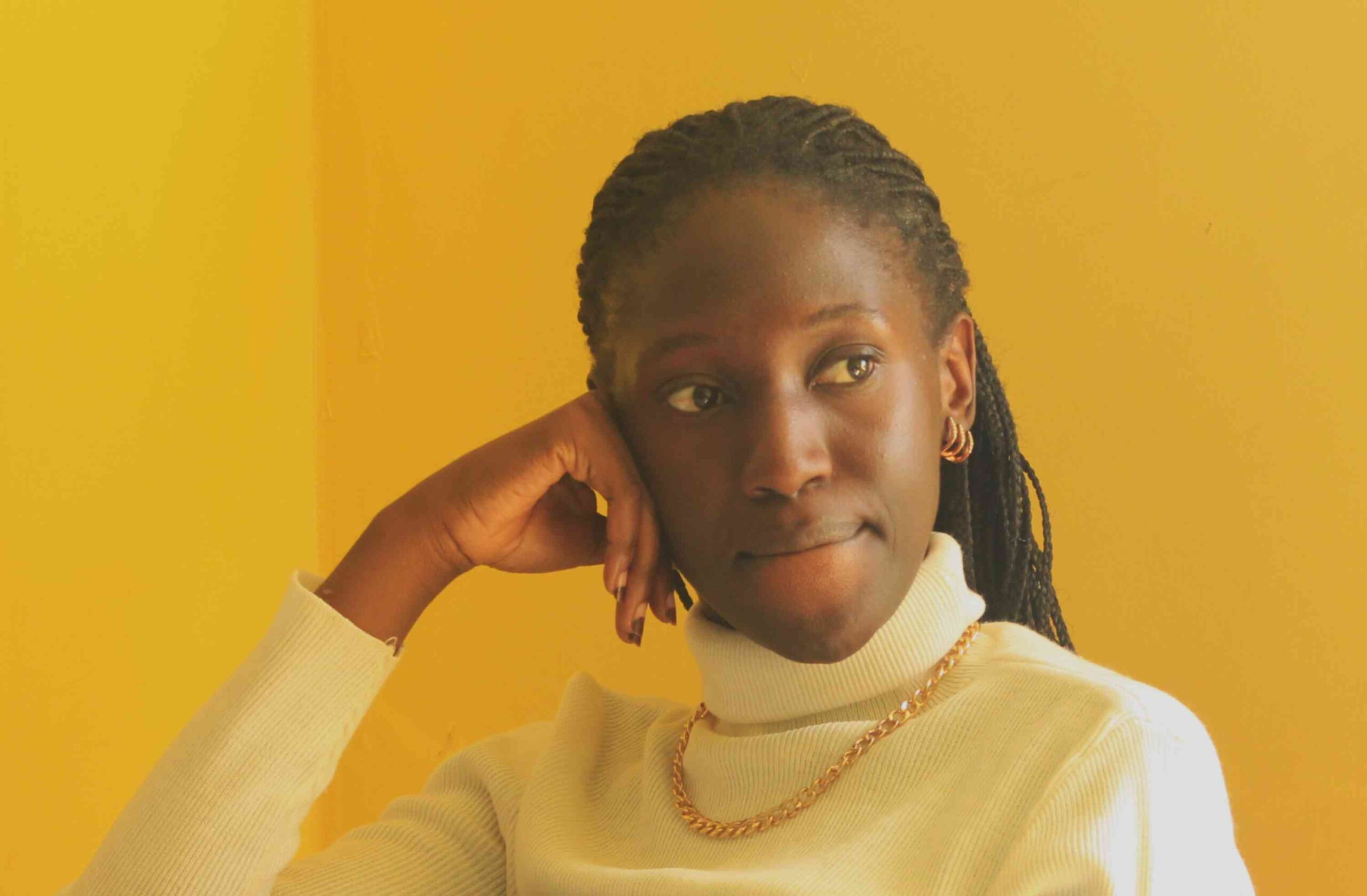 A young African girl is staring ahead of her. She is biting her lips.