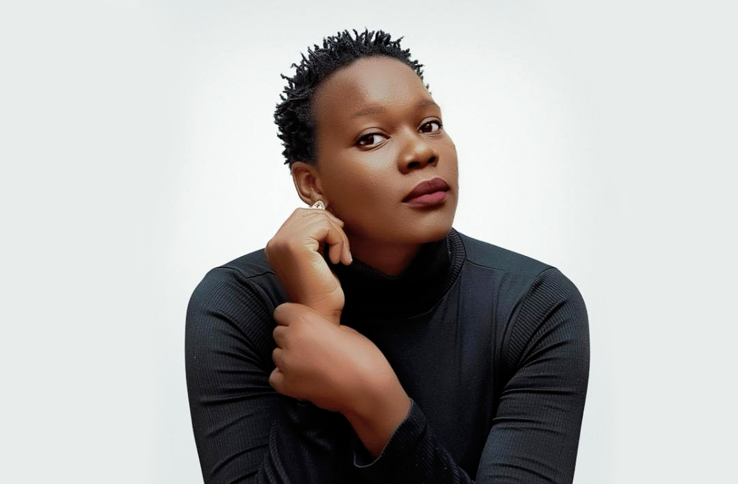 A young woman posing for a photo in a black shirt.