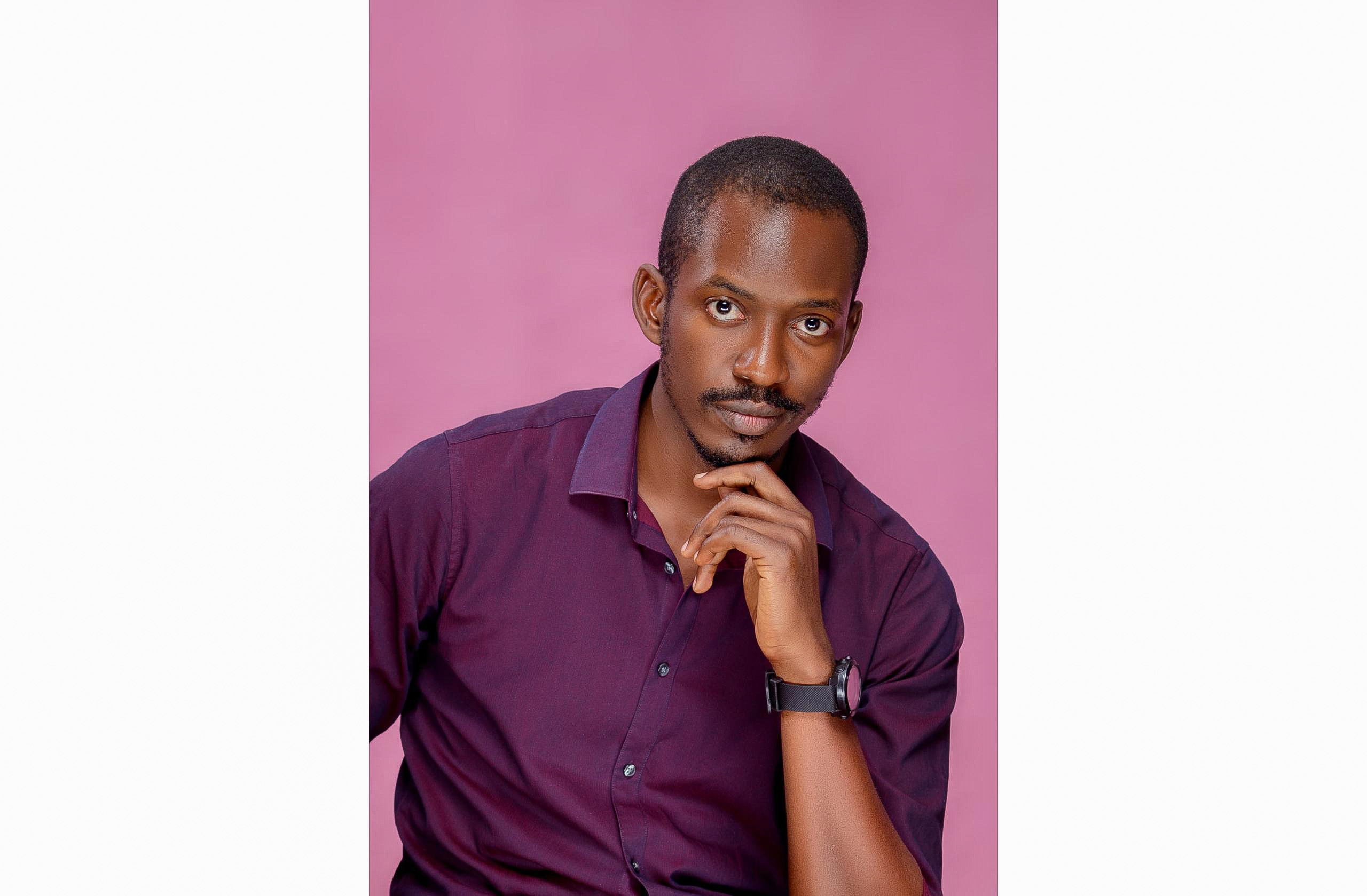 A young man posing for a photo in a purple shirt.